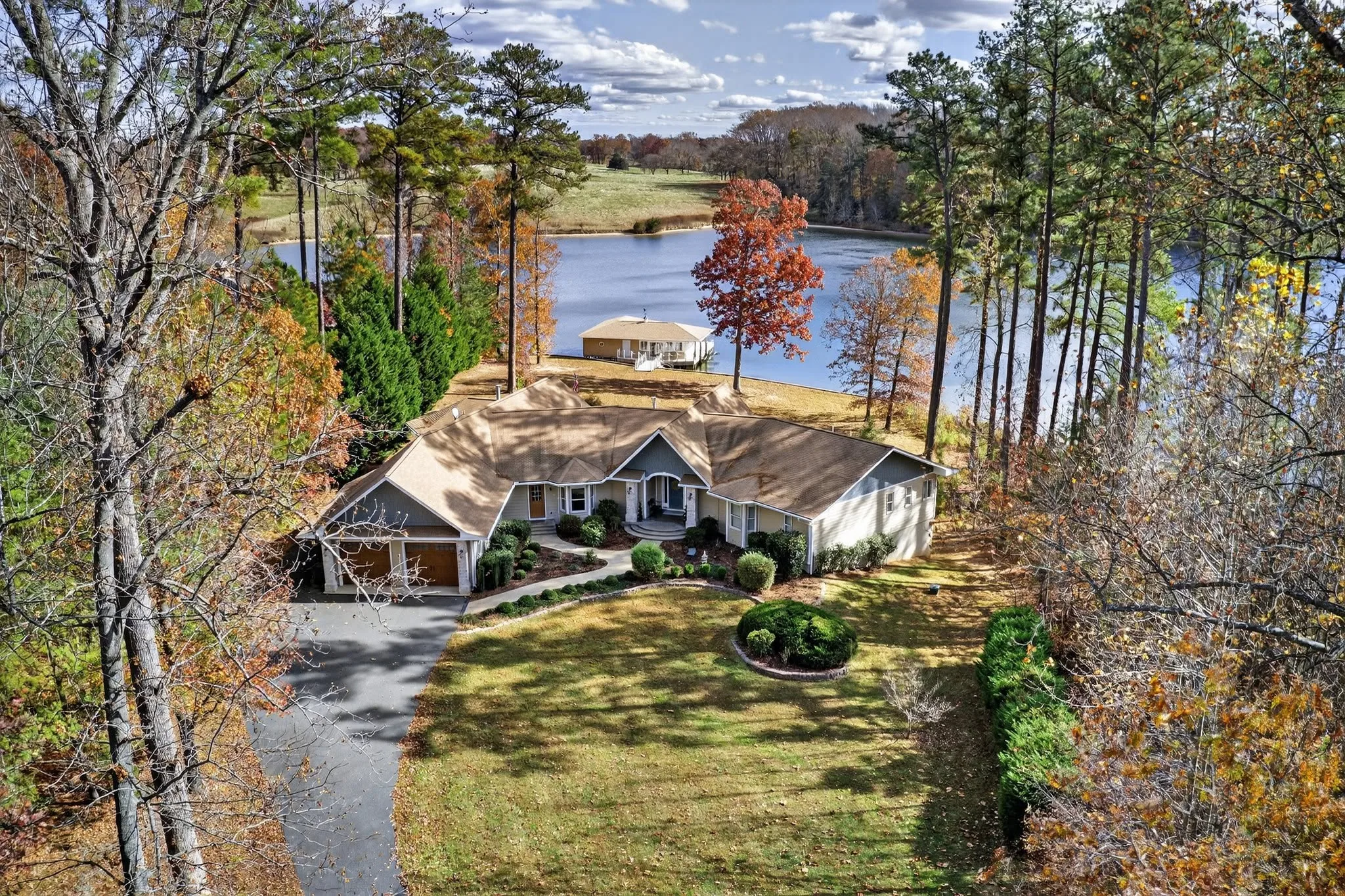 Aerial view of a lakefront home surrounded by trees in autumn color on a Northern Virginia lake