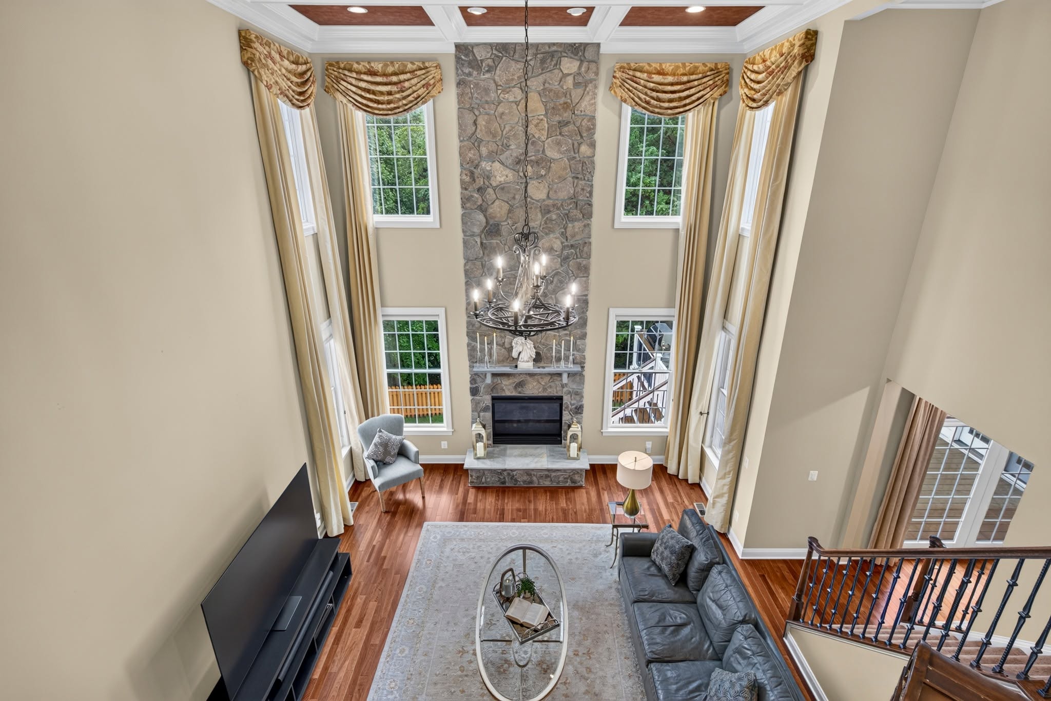 Two-story great room with a stone fireplace and a second-story overlook